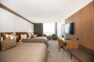 a hotel room with two beds and a television at Distinction Invercargill Hotel in Invercargill