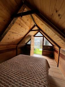 a large bed in a room with a large window at Cabaña Bambú - Roca Glamping Suesca in Santa Isabel