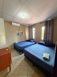 two beds in a room with blue sheets at Cozy beach house getaway in La Libertad +27 photos