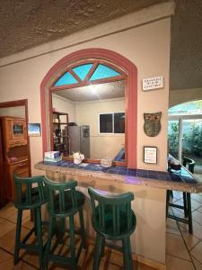 a kitchen with a counter with four green bar stools at Cozy beach house getaway in La Libertad