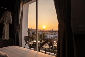 a room with a balcony with a table and chairs at Aslan Boutique Apartments in Patong Beach