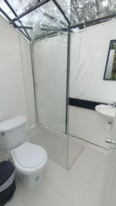 a white bathroom with a toilet and a sink at DOMO Roca Glamping Suesca in Suesca