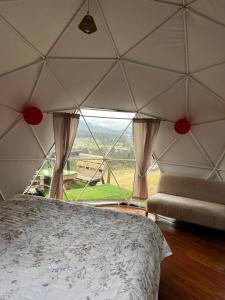 a bedroom with a bed and a large window at DOMO Roca Glamping Suesca in Suesca +17 photos