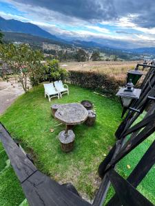 a patio with a table and chairs on the grass at DOMO Roca Glamping Suesca in Suesca