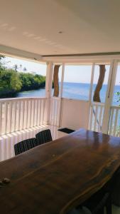a table and chairs on a balcony with the ocean at Poseidon White Sand Resort & Cave in Santa Rosa