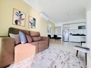 a living room with a brown couch and a kitchen at Studio Mandarin + spectacular view + Umarizal in Belém