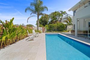 a swimming pool with two chairs next to a house at Southwind in Sunrise in Sunrise Beach