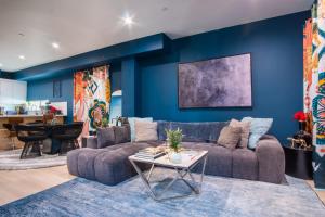 a living room with a couch and a blue wall at Jardin Noir at Case Collective in North Hollywood
