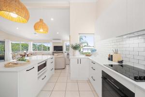 a white kitchen with white appliances and a dining room at Southwind in Sunrise in Sunrise Beach