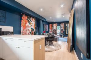 a kitchen with blue walls and a living room at Jardin Noir at Case Collective in North Hollywood +19 photos