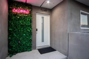 a building with a green wall with a white door at Jardin Noir at Case Collective in North Hollywood
