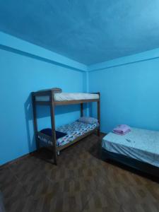 a room with two bunk beds in a blue room at Apartamentos Ines in Puerto Iguazú