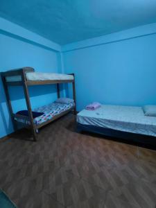 two bunk beds in a room with a blue light at Apartamentos Ines in Puerto Iguazú