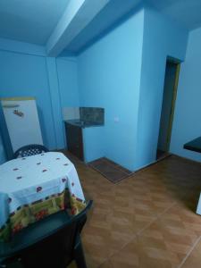 a blue room with a bed and a table at Apartamentos Ines in Puerto Iguazú