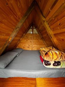 a bed in a room with a wooden ceiling at Mini Cabaña Roca Glamping in Suesca
