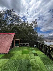 a house with a large yard with green grass at Mini Cabaña Roca Glamping in Suesca