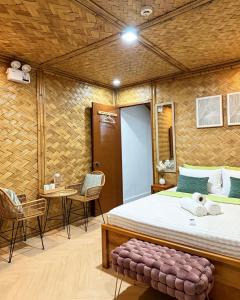 a room with a bed and a table and chairs at Sirem Beach Resort in Puerto Princesa City