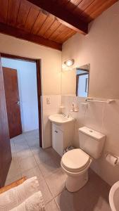 a bathroom with a white toilet and a sink at Trono de Nubes in Trevelín