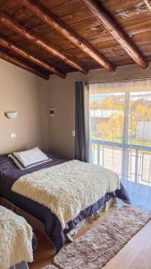 a bedroom with two beds and a large window at Trono de Nubes in Trevelín