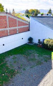 a brick retaining wall next to a house at Trono de Nubes in Trevelín