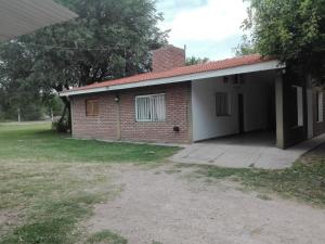 a brick house with a garage and a yard at Cabañas El Monchito in Juana Koslay 
