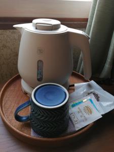 eine Kaffeemaschine und eine Tasse auf einem Tablett in der Unterkunft あらさんち in Asahikawa