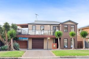 a house with palm trees in front of it at Portarlington Gem in Portarlington