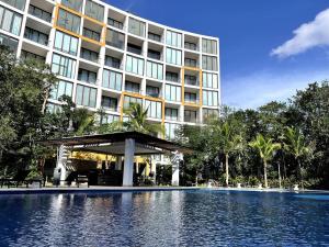 a hotel with a swimming pool in front of a building at Paradise in a rainforest reserve B 503 in Playa del Carmen