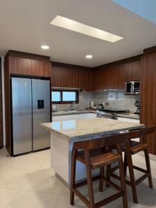 a kitchen with a refrigerator and a table with stools at Paradise in a rainforest reserve B 503 in Playa del Carmen