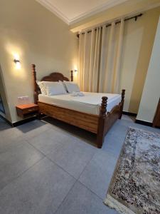a bedroom with a bed with white sheets and pillows at Al-mendhiry Apartment in Zanzibar City