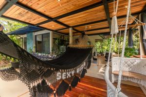a hammock on the porch of a house at Con Amor Caribe - New 240 sqm Villa & Private Pool in Puerto Viejo +40 photos