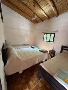 a bedroom with two beds and a window at Cabañas El Cardón in Maimará