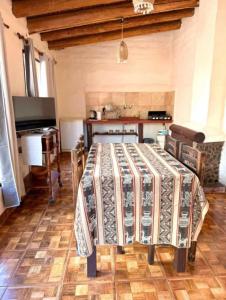 a dining room with a table with a blanket on it at Cabañas El Cardón in Maimará +7 photos
