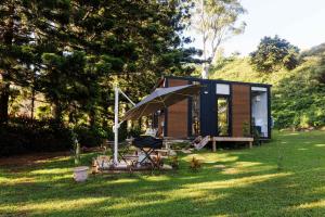 a tiny house with a picnic table and an umbrella at Montville Retreat by Tiny Away in Montville