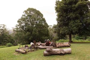a group of people sitting around a table in a field at Montville Retreat by Tiny Away in Montville