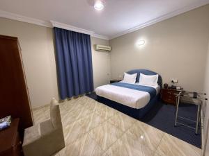 a hotel room with a bed and a chair at شركه أركان الذهبيه الحديثه للشقق المخدومه in Abha