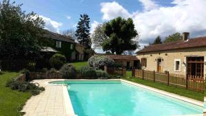 una piscina en un patio junto a una casa en La Croisée Verte en Veyrines-de-Vergt