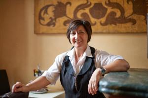 une femme assise à une table dans une pièce dans l'établissement Hotel Cosimo de' Medici, à Florence