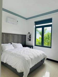 a bedroom with a large bed and a window at Suoi Da Villa in Ðồn Bãi Cả