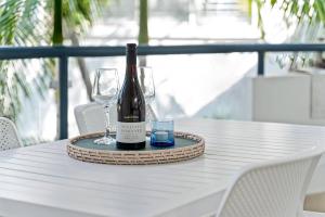 a bottle of wine and two glasses on a table at Immaculate Riverside Apartment With Heated Pool in Noosaville