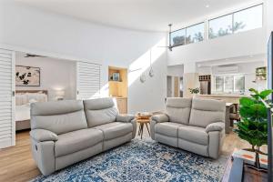 a living room with two chairs and a bed at Immaculate Riverside Apartment With Heated Pool in Noosaville