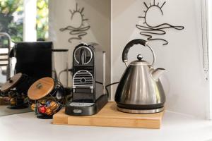 a tea kettle on a counter next to a toaster at Whispering Waves Pet Friendly Steps to Beach in Peregian Beach +12 photos