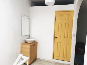 a bathroom with a yellow door and a sink at Casa Aire y Luz in Pereira