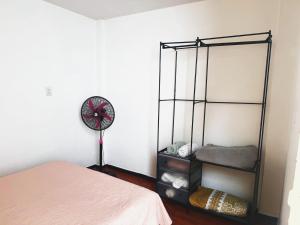 a room with a bed and a fan and a clock at Casa Aire y Luz in Pereira +4 photos