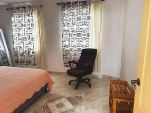 a bedroom with a chair in front of a window at Casa Aire y Luz in Pereira