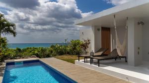 a villa with a swimming pool in front of a house at Feliz Villa Suite Miyakojima Ueno in Miyako-jima