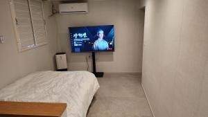 a bedroom with a bed and a flat screen tv at Jin Stay Hotel in Changwon
