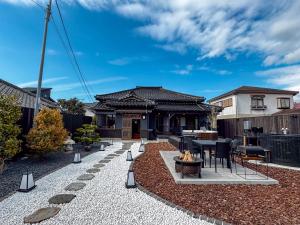 a backyard with a fire pit and a house at 陽和リトリート in Tateyama