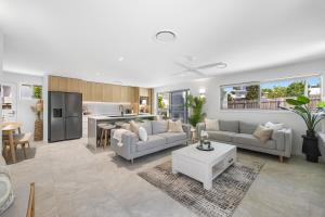 a living room with a couch and a table at Spacious 4-Bed Coastal Home with Pool in Mooloolaba