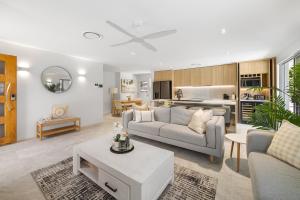 a living room with a couch and a table at Spacious 4-Bed Coastal Home with Pool in Mooloolaba